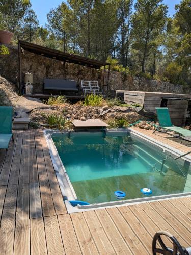 - une piscine sur une terrasse en bois avec une table et des chaises dans l'établissement Au Bonheur des Dames, à Vedène