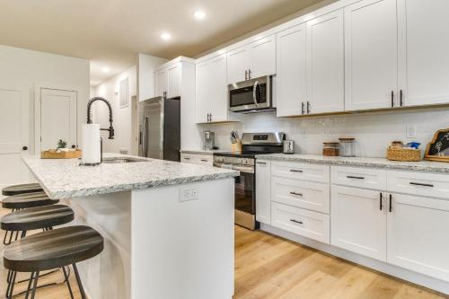 a kitchen with white cabinets and a counter with stools at Flippin Vacation Rental Walk to White River! in Flippin