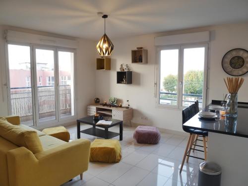 un salon avec un canapé et une table dans l'établissement Appartement à 15 minutes de Paris, proche gare, au Bourget