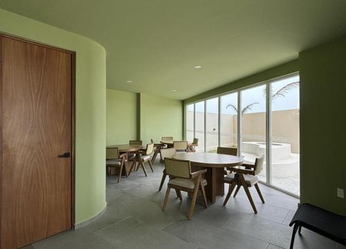 a dining room with tables and chairs and a large window at Departamento con vista al mar en Cabo Marino in Conchal