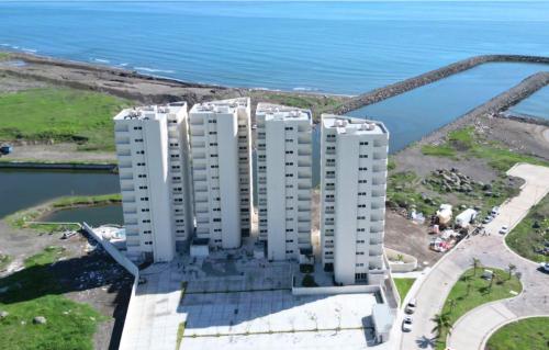 an aerial view of a white apartment building by the water at Departamento con vista al mar en Cabo Marino in Conchal