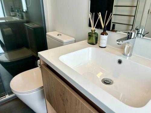 a bathroom with a white sink and a toilet at Point Wells Casita in Omaha