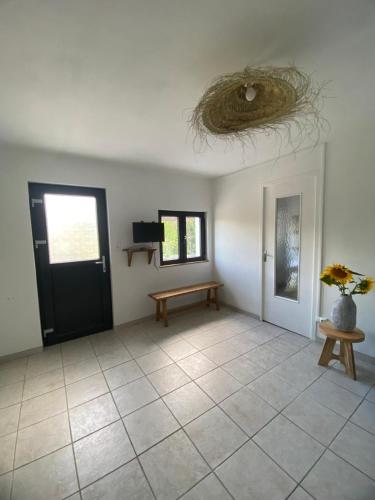 une chambre avec une porte noire, un banc et une table dans l'établissement Maison au bord du lac de saint Ciergues, à Perrancey