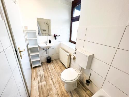 a bathroom with a toilet and a sink at Krefeld House Deluxe Apartment - 15min to DUS & FREE Parking in Krefeld