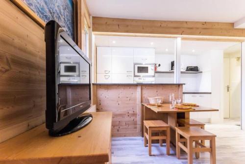 une télévision posée sur une table en bois dans une cuisine dans l'établissement Résidence Les Cotes - Bel appartement rénové proche espace Paradisio MAE-8681, à Aime La Plagne