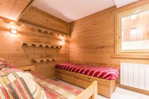 Cette cabane en rondins comprend un lit et une fenêtre. dans l'établissement Résidence Les Cotes - Bel appartement rénové proche espace Paradisio MAE-8681, à Aime La Plagne