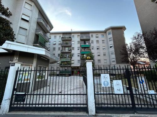 a fence in front of a building with signs on it at Your home in Milan - Elegant & Comfortable Stay in Crescenzago