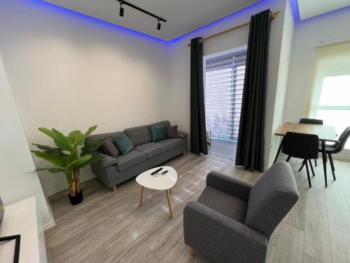 a living room with a couch and a table at Sunflower Apartment in Tirana