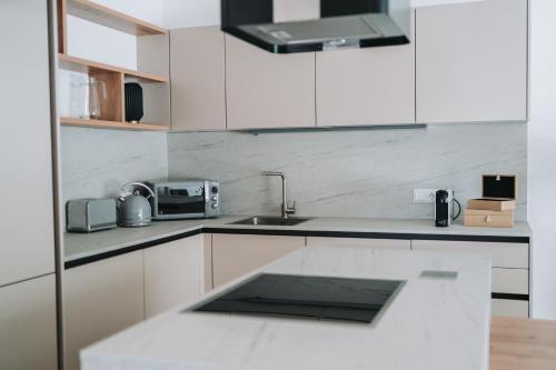 a kitchen with white cabinets and a sink at Apartment KUS Velden in Velden am Wörthersee