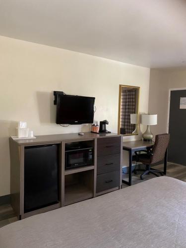 a room with a flat screen tv on a entertainment center at Quality Inn & Suites Goodyear - Phoenix West in Goodyear