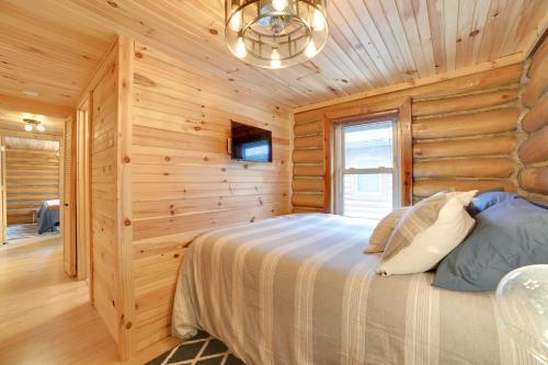 a bedroom with a bed in a wooden wall at Diamond Lake Waterfront Cabin with Deck and Dock! in Tustin