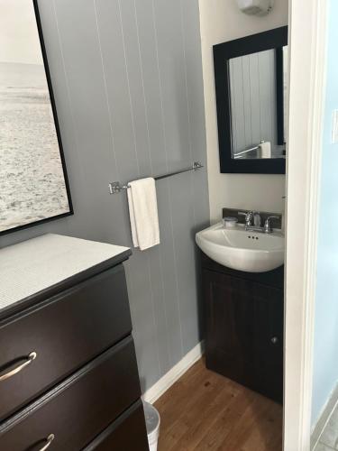 a bathroom with a sink and a mirror at Motel de L'Anse et Camping Rimouski in Rimouski
