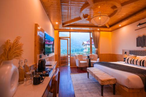 a bedroom with a bed and a desk with a television at Olgah Manali in Manāli