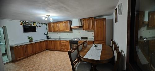 a kitchen with wooden cabinets and a table with chairs at Casa Ramo in Râşnov