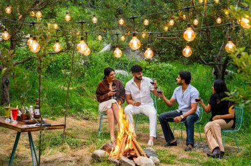 a group of people sitting around a fire at Olgah Manali in Manāli