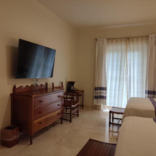 a bedroom with a dresser and a flat screen tv at Hotel Marques Del Valle in Oaxaca City