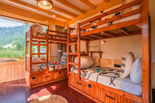 two bunk beds in a room with a window at Olgah Manali in Manāli