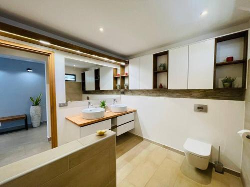 a bathroom with two sinks and a toilet at Villa Moana Reva in Bora Bora