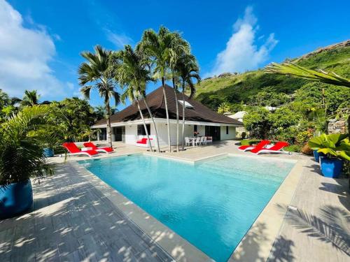 a villa with a swimming pool and palm trees at Villa Moana Reva in Bora Bora