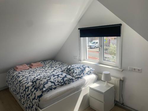 a small bedroom with a bed and a window at Torensduin aan zee in Egmond aan Zee
