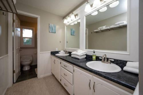 a bathroom with a sink and a toilet and a mirror at Hobbs Mill with Theatre, Ping Pong, and Pet-Friendly in Layton