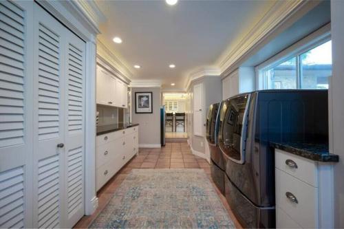 a large kitchen with white cabinets and a large window at Hobbs Mill with Theatre, Ping Pong, and Pet-Friendly in Layton