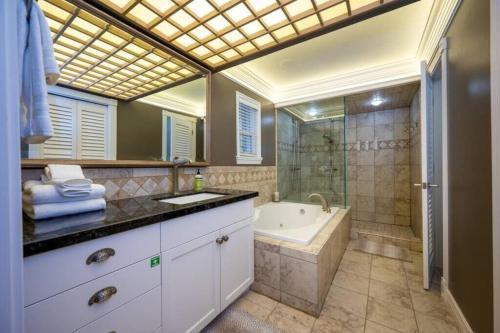 a bathroom with a tub and a shower and a sink at Hobbs Mill with Theatre, Ping Pong, and Pet-Friendly in Layton