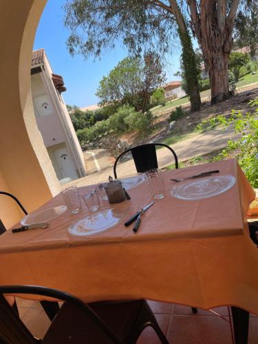 a table with glasses and plates on it with a window at Appartement 2 pièces bord de mer in Linguizzetta