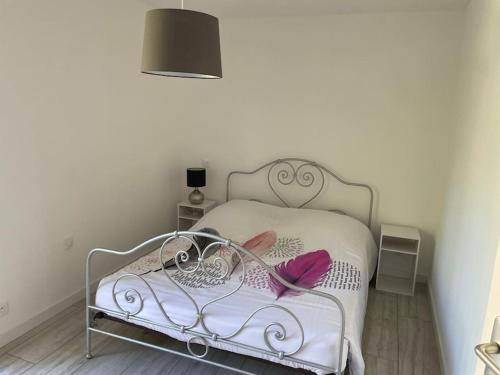 a bedroom with a white bed with pink towels on it at Maison avec jardin et terrasse in Labruguière