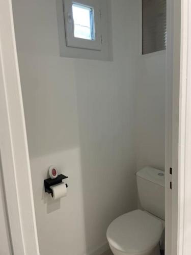 a white bathroom with a toilet and a window at Maison avec jardin et terrasse in Labruguière