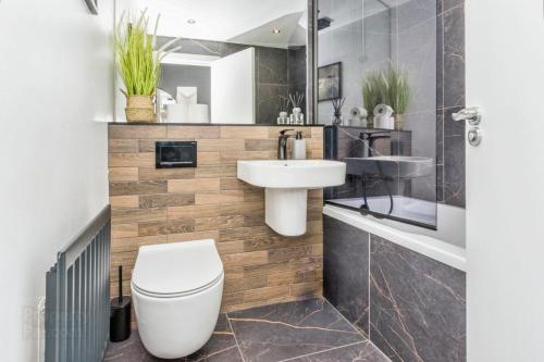 a bathroom with a white toilet and a sink at Modern Hut in Belfast in Belfast