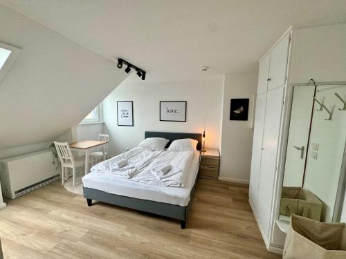 a bedroom with a bed and a table in a room at gina stay - Ferienwohnung 200m vom Strand in Büsum in Büsum