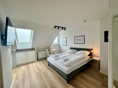 a bedroom with a bed and a desk and a window at gina stay - Ferienwohnung 200m vom Strand in Büsum in Büsum