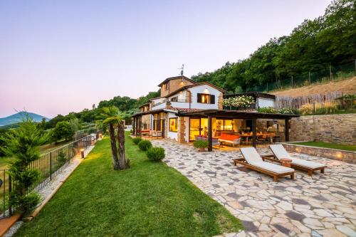 a house on a hill with a patio and a yard at Villa Destino Italy, Umbria Tuscany boarder in Montone