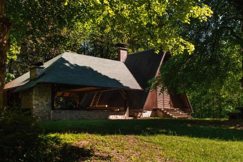 una casa in pietra con tetto a padiglione su un prato di Cottage Koča Oaza Preske a Jurklošter