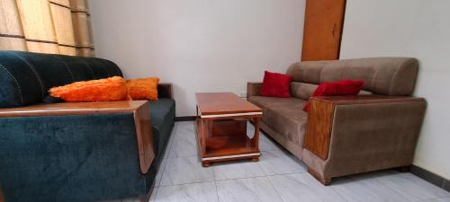 a living room with two couches and a table at Marigold Motel 