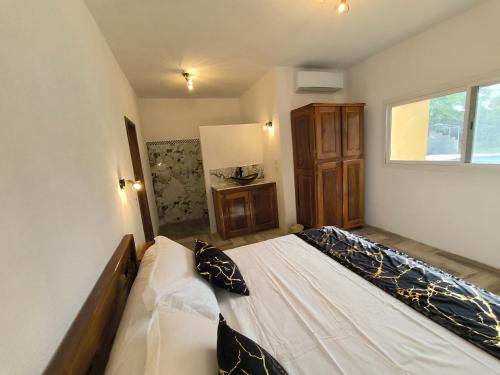 a bedroom with a large bed with pillows on it at Campement Houefa in Ndangane