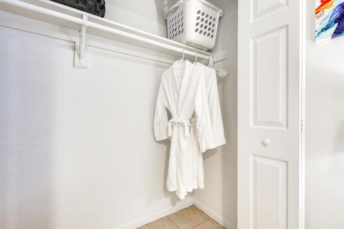 a white robe hanging on a closet door at 2 Mi to Dtwn Hollywood Vibrant Pet-Friendly Condo in Hallandale Beach