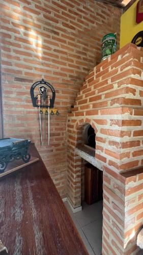 a brick oven with a table in front of it at Chalé da Montanha in Resende