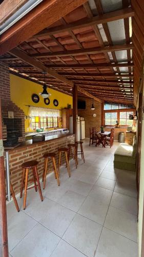 a kitchen and dining room with wooden ceilings and tables at Chalé da Montanha in Resende