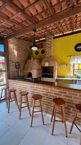 a group of stools in front of a kitchen at Chalé da Montanha in Resende