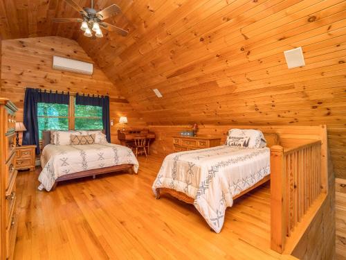 ein Schlafzimmer mit zwei Betten in einer Blockhütte in der Unterkunft SUNDAY RIVER VIEWS!! Minutes from the mountain! in Newry