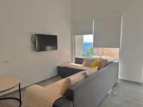 a living room with a couch and a tv at Sea Horizon Vsl Suites & Apartments in Sarandë