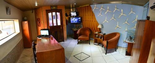 uma sala de estar cheia de mobiliário e uma televisão em Posada Colonial em Assunção