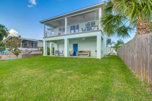 a white house with a fence and a yard at Riverfront Homosassa Retreat with Kayak and Boat Dock! in Homosassa