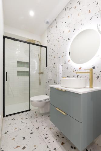 une salle de bain avec toilettes, lavabo et miroir dans l'établissement joli & charmant au centre Millau, à Millau