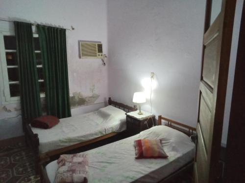 two beds in a small room with a window at CASA Centro in Santiago del Estero