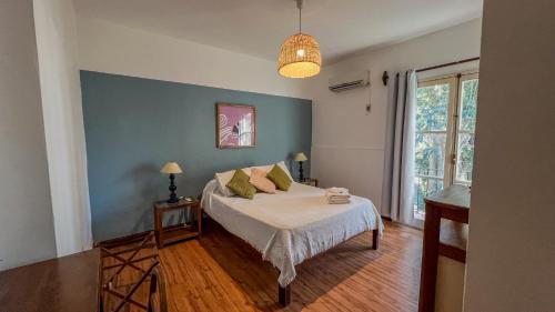 a bedroom with a bed and a blue wall at Viajero Colonia Hostel in Colonia del Sacramento