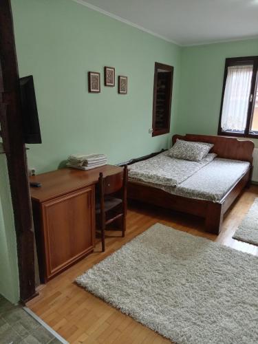 a room with two beds and a desk and two rugs at **ETNO Vila** - KRUSEVO in Kruševo