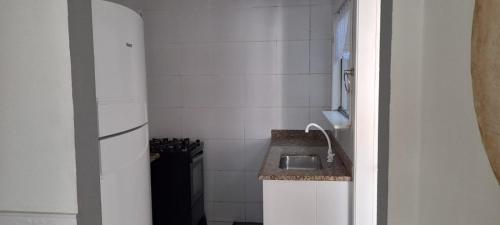 uma pequena cozinha com pia e geladeira em Linda casa para temporada no Peró/Cabo Frio em Cabo Frio